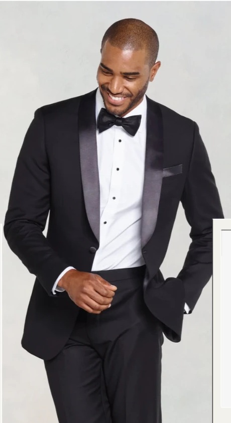 A gentleman in a classic black shawl-lapel tuxedo with a black bow tie